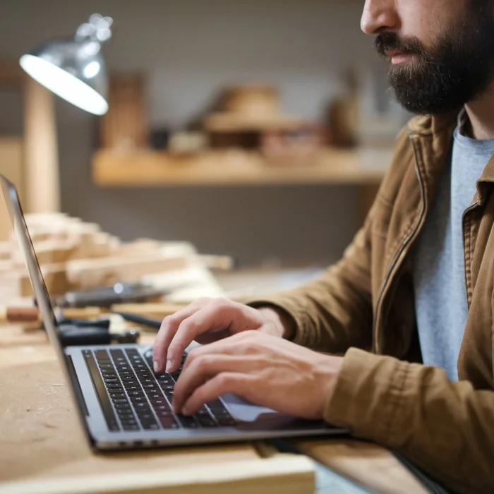 man-with-beard-using-laptop-with-beard-brown-jacket